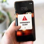 Smartphone showing emergency alert notification for LMC Alert system in Lalitpur
